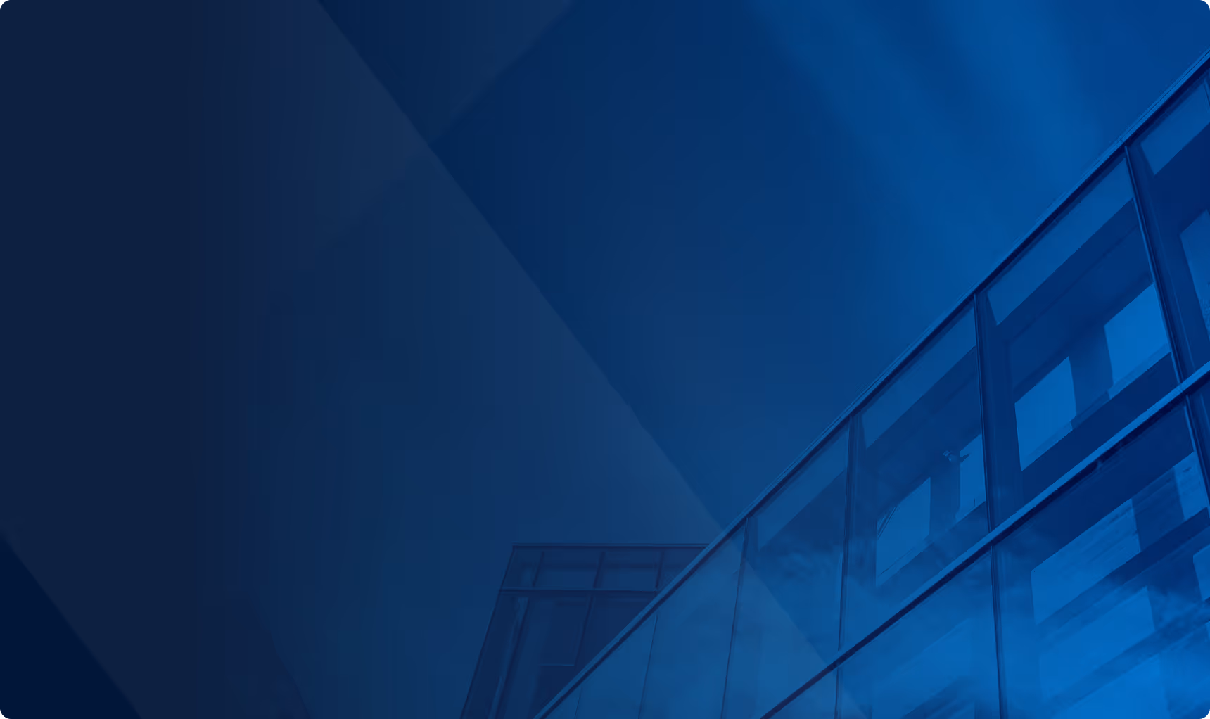 Widok nowoczesnego szklanego budynku biurowego pod niebem, utrzymany w niebieskiej kolorystyce.