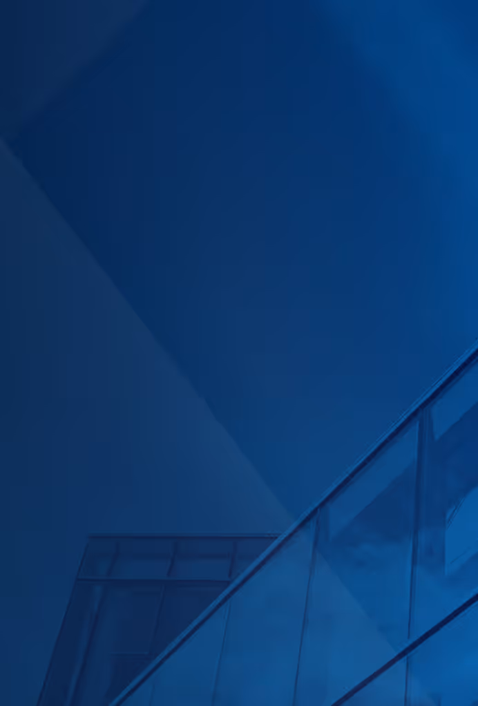 Fragment nowoczesnego budynku z dużymi szklanymi panelami i niebieskim filtrem.