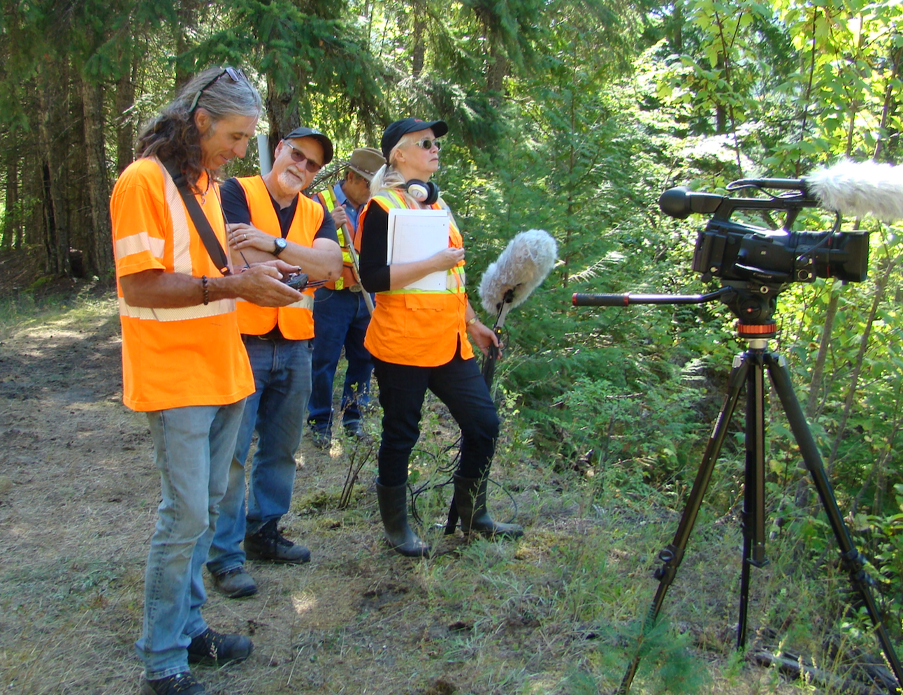 Why are we are always wearing those high-visibility vests?  Because we are filming near heavy equipment and this is a safety requirement. In the photo (l to r): drone cameraperson Marty Agabob, director of photography Mark Wolfe, Wayne McCrory (in background) and film editor Kerry McArthur.