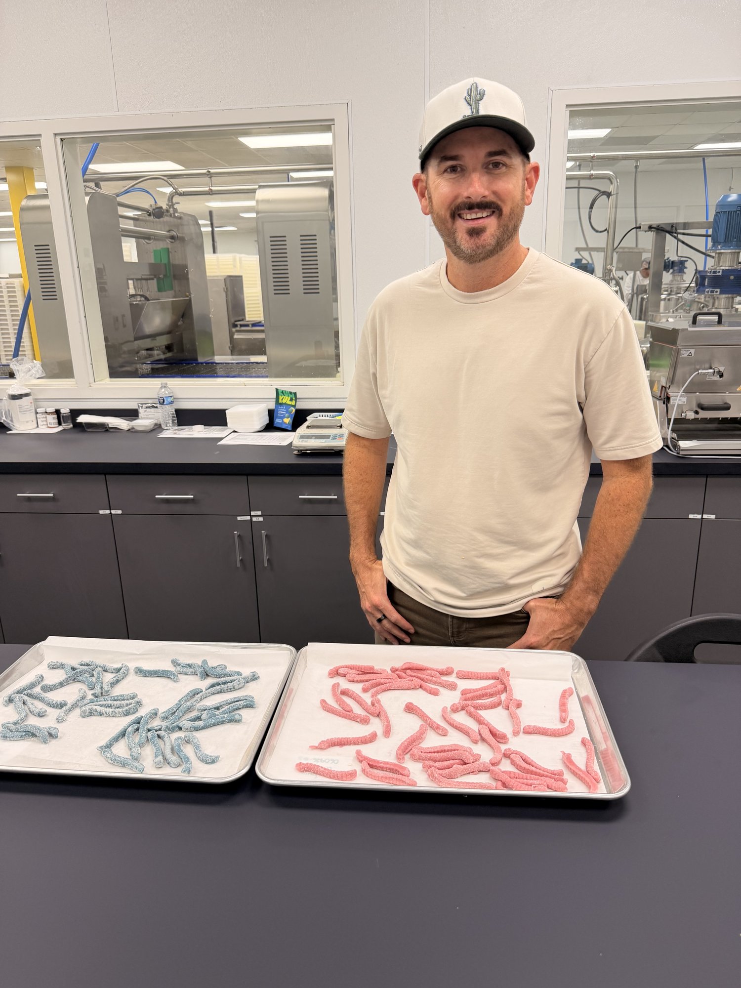 Cameron Gawley tasting GLiTCH high-protein sour gummy worms at a candy formulation bench trial