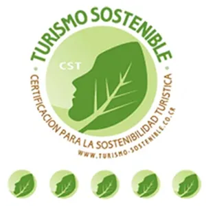 Green logo with a leaf silhouette of a face, labeled Turismo Sostenible, certification for tourism sustainability.