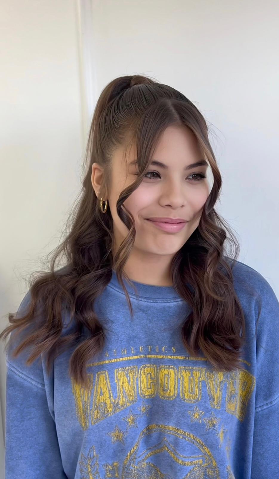 Portrait of a young woman with wavy brown hair in green top
