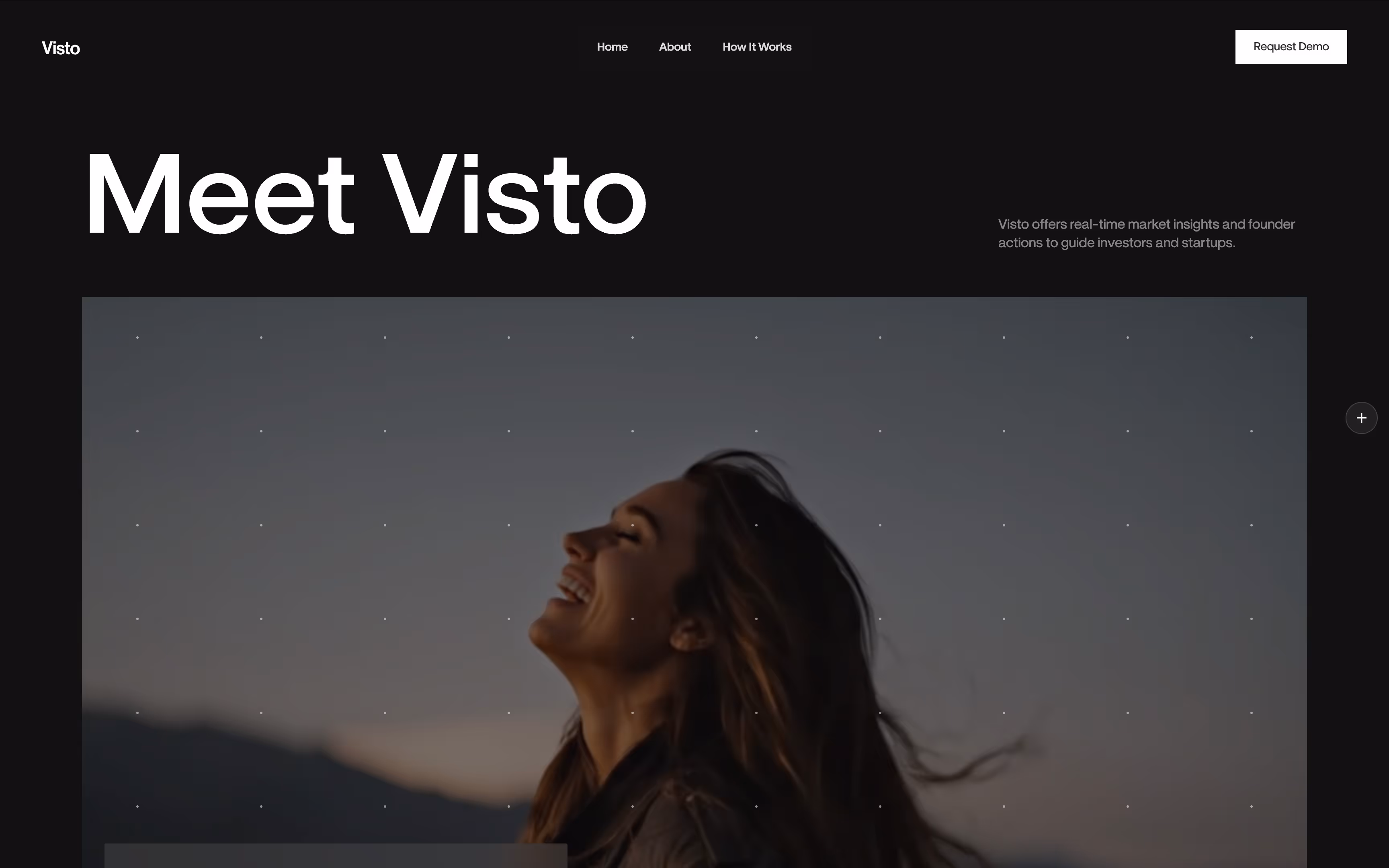 Smiling woman with long hair looking upward outdoors at dusk with a blurred mountain background.
