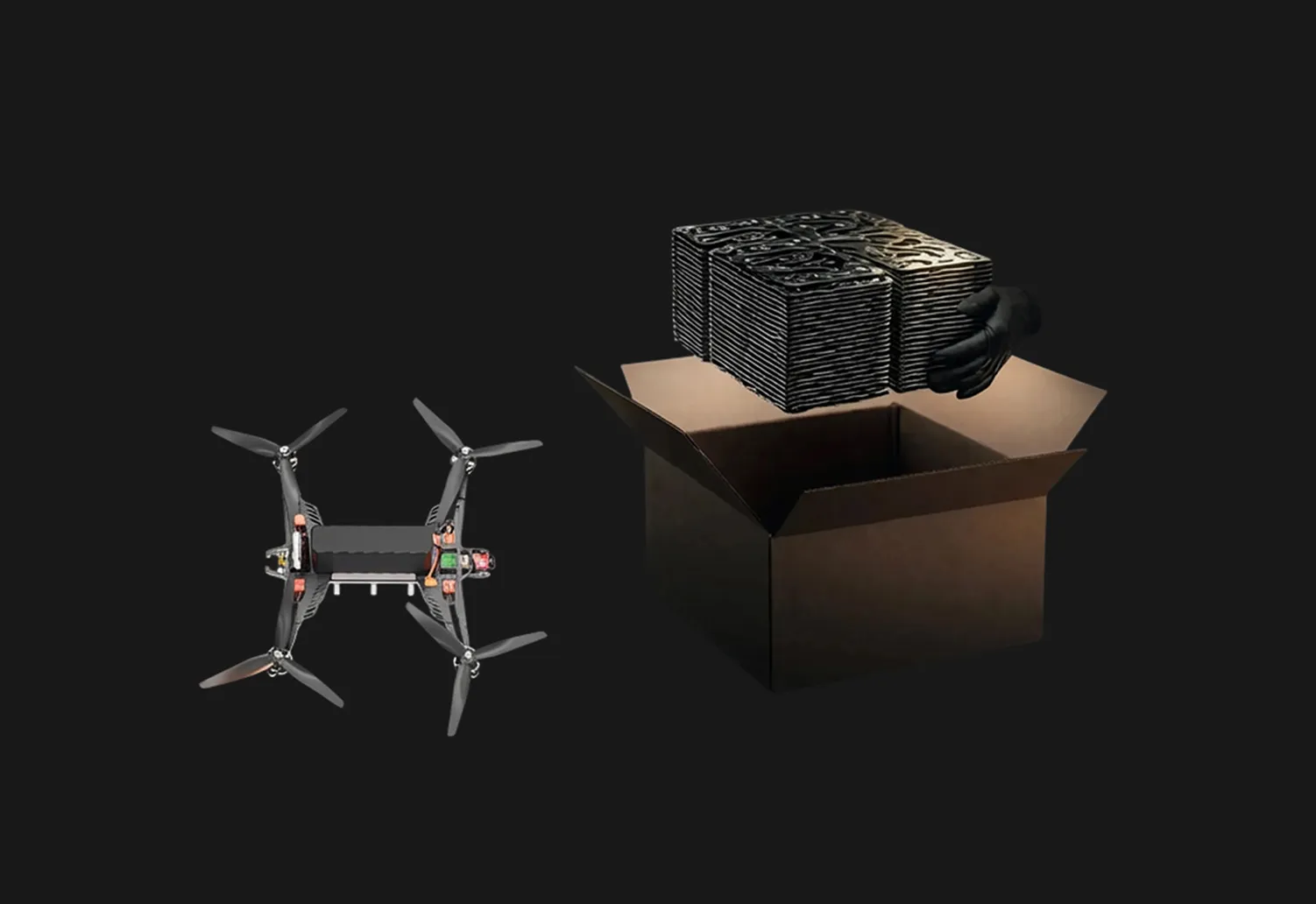 Black quadcopter drone with four propellers next to an open cardboard box holding a gloved hand lifting a stack of black square objects.