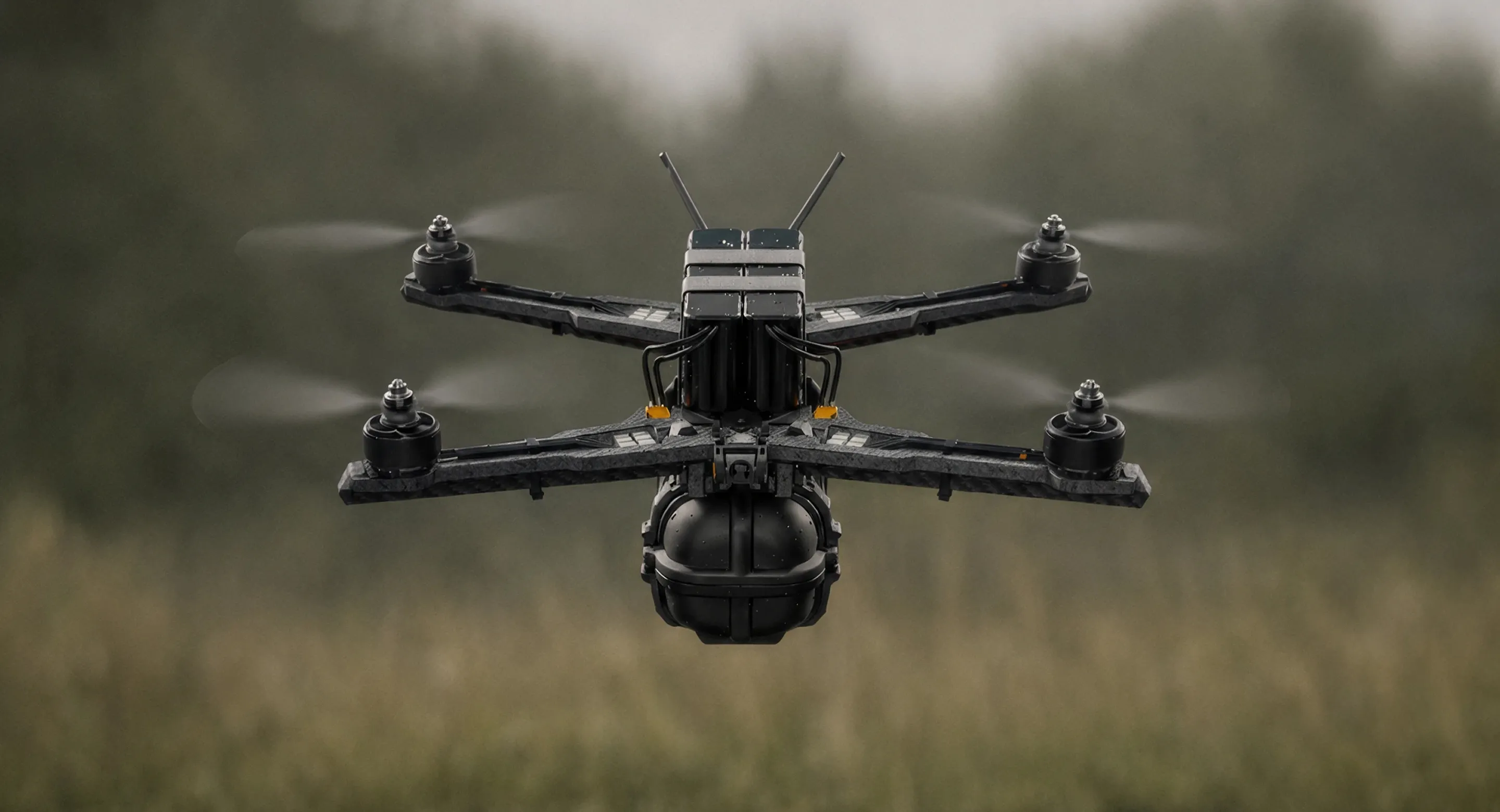 Black quadcopter drone flying over a grassy field with blurred trees in the background.