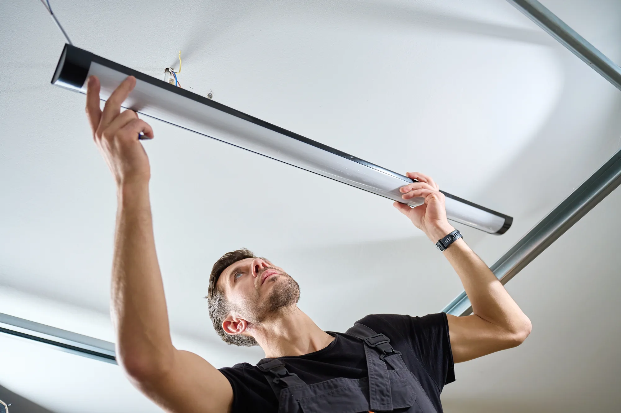 Electrician fitting a replacement tube light during an LED retrofit