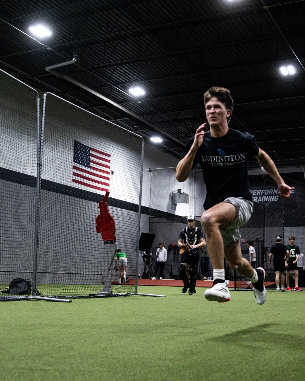The athlete is performing a broad jump, a standard drill in baseball training to develop lower-body power and explosive hip extension for batting and throwing velocity