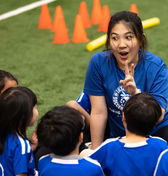 a lively moment in a Lil' Kickers class, a well-known non-competitive child development program that teaches foundational motor and soccer skills through creative play