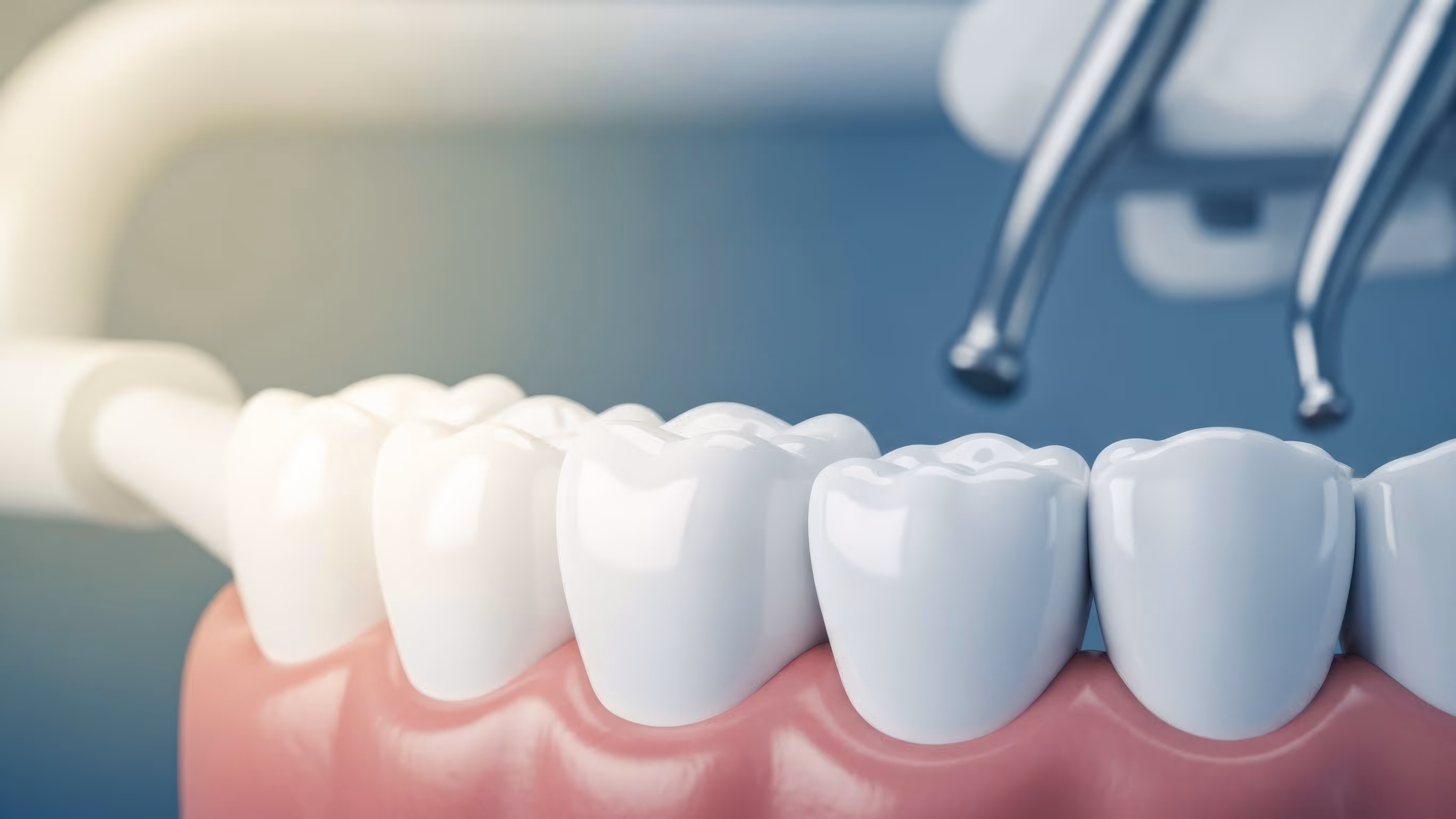 Close-up of dental model showing white teeth and gums with dental tools positioned above.