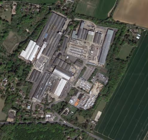Aerial view of an industrial complex surrounded by fields and trees.