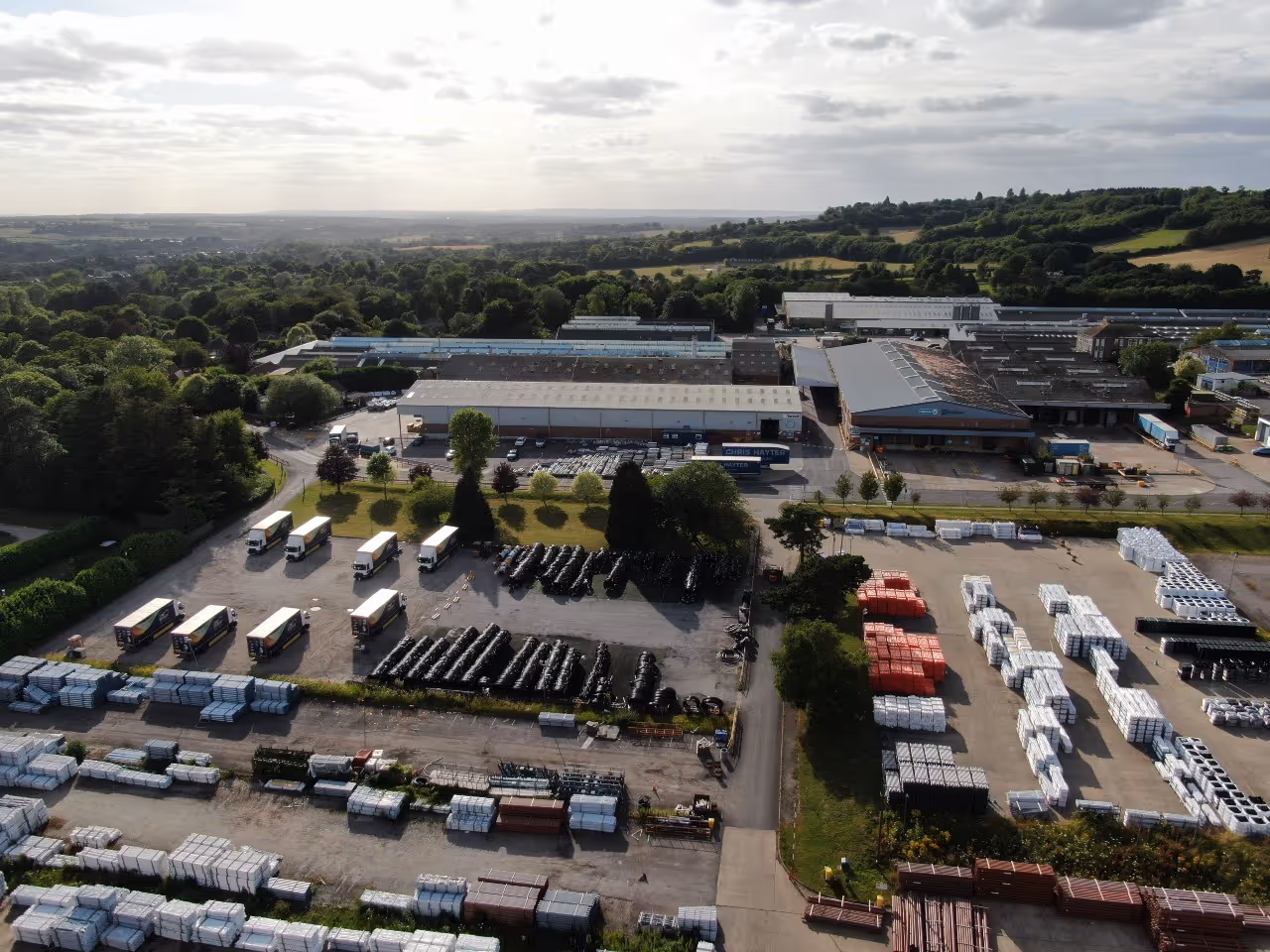 Black and white image of a busy industrial workshop with several workers operating machinery and equipment.