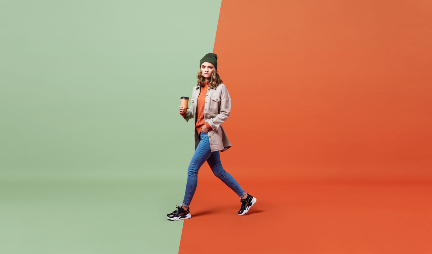 En høstkledd kvinne beveger seg bortover i et fargerikt fotostudio