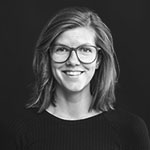 Ansattbilde i svart hvitt av en smilende kvinne med briller