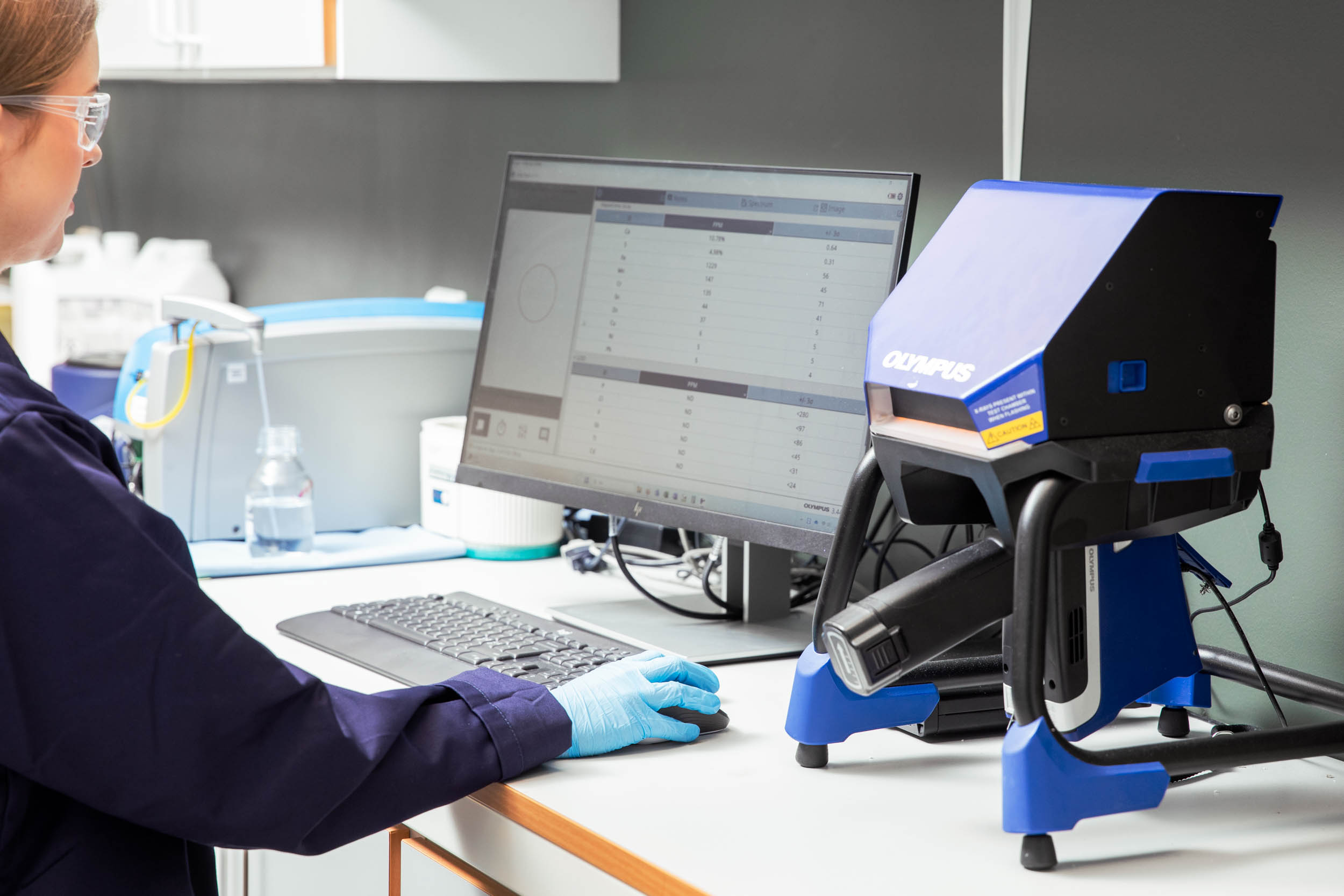 En kvinne står foran en dataskjerm inne på en lab og jobber