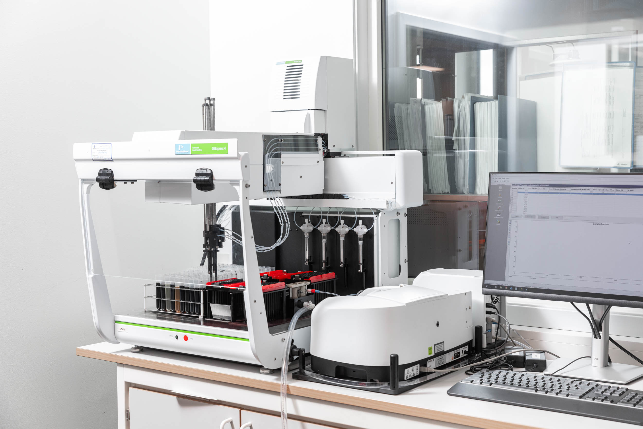 En hvit doseringsmaskin på en pult inne på en lab