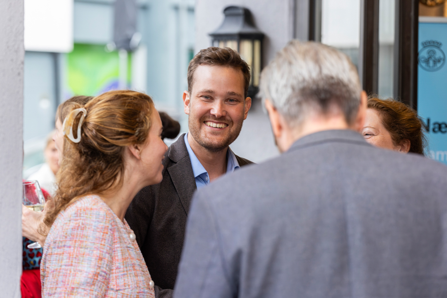 En ung mann ser i kamera mens hann står i en liten gruppe