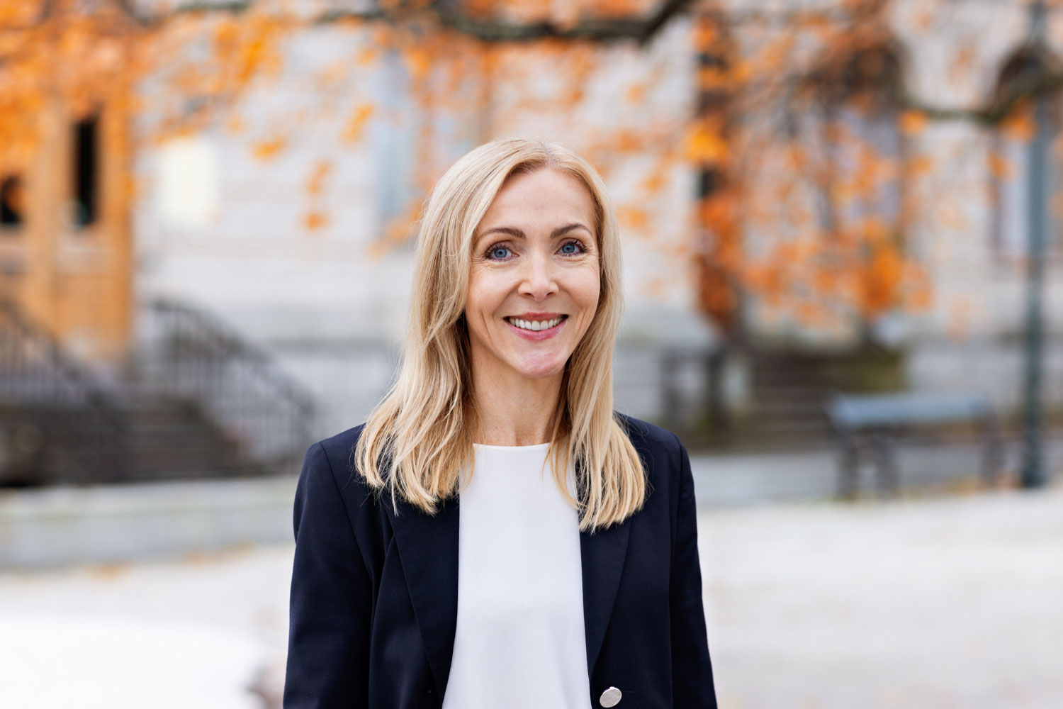 Portrettbilde av en blond kvinne som står ute på gata