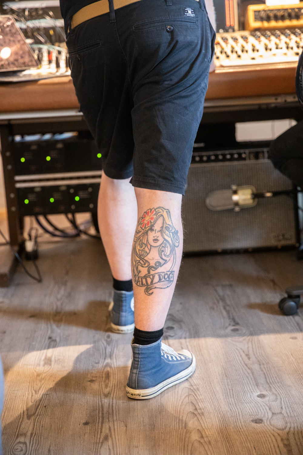 Nærbilde av et bandmedlem fra Nullskattesnylterne som lener seg mot en mixepult i et studio