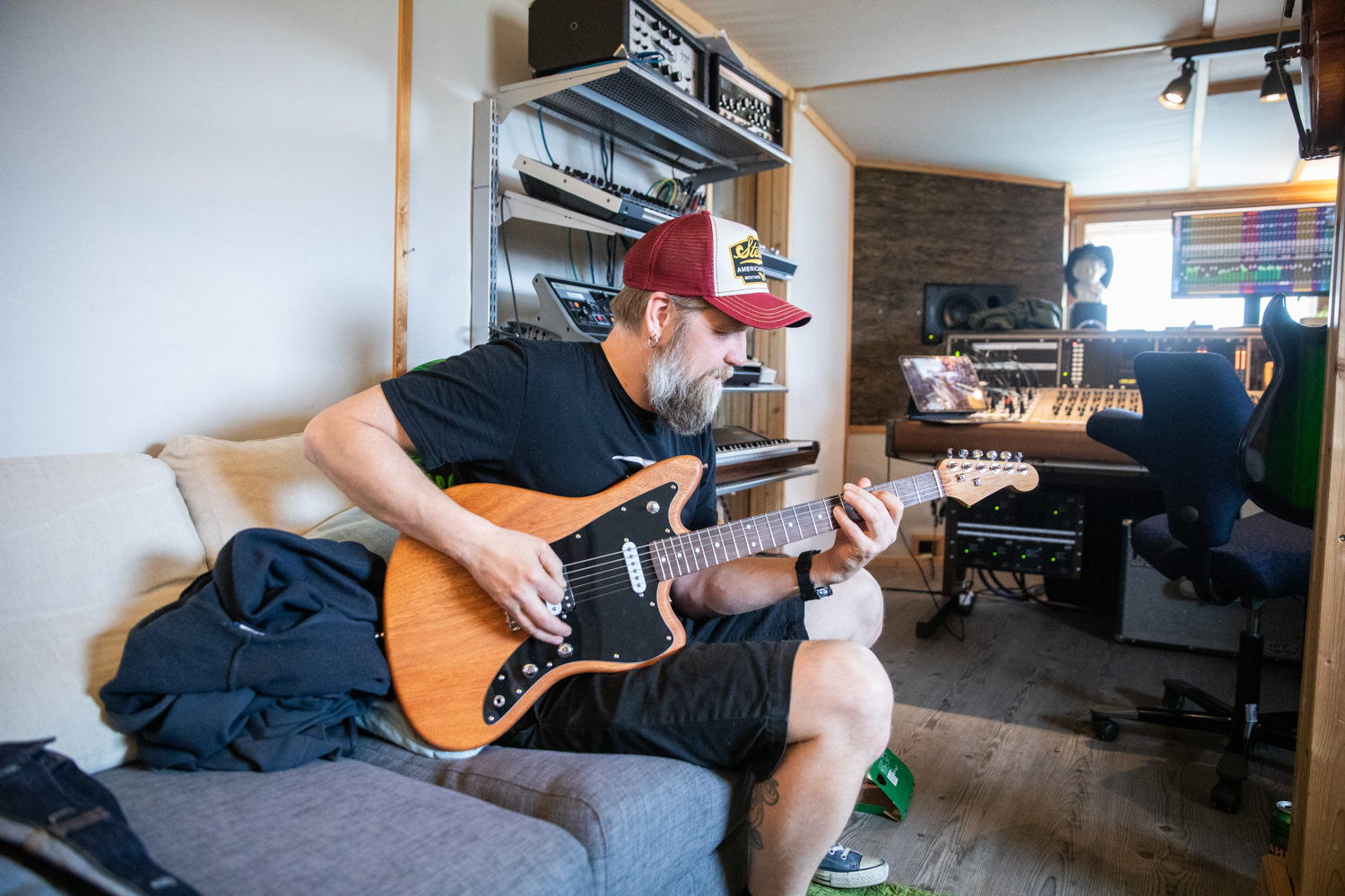 En total av en gitarist fra rockebandet Nullskattesnylterne sitter inne på kontrollrommet og spiller gitar