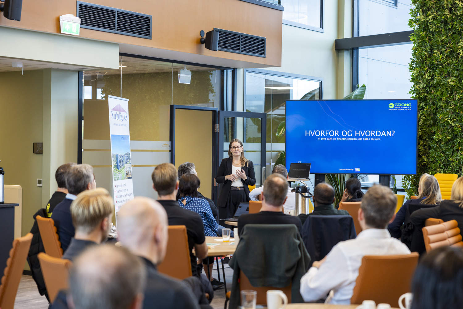 En kvinne presenterer på vegne av Grong Sparebank, i forgrunnen et tilskuere som hører på