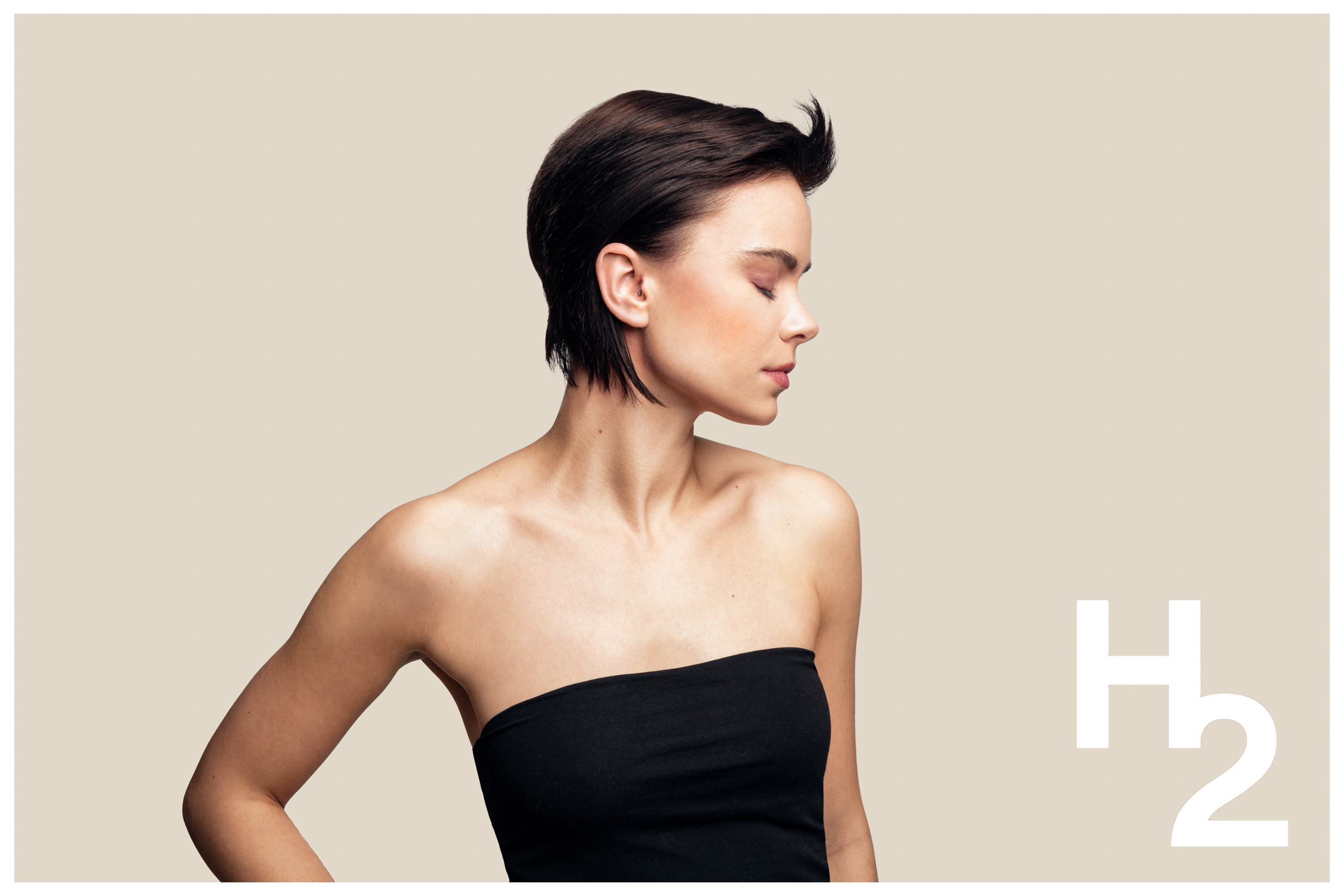 En ung kvinne med kort og mørkt hår poserer i et studio