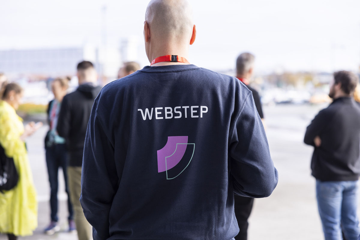 Ryggen av en mann i en folkemengde nede ved havet