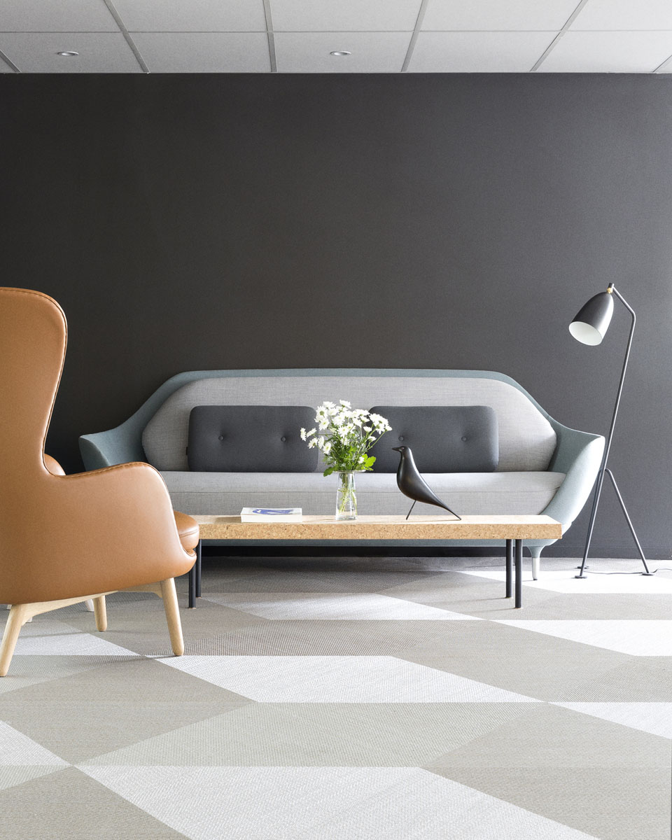 Grå sofa i sittesone i et moderne kontorfelleskap