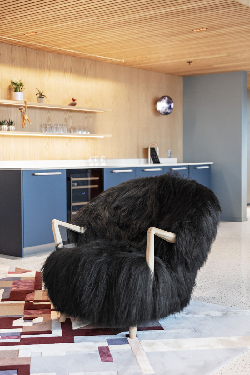 En svart stol i en sittesone i et moderne kontorlandskap