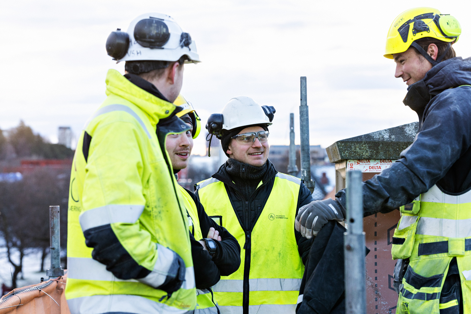 Tre menn jobber sammen på et hus under konstruksjon