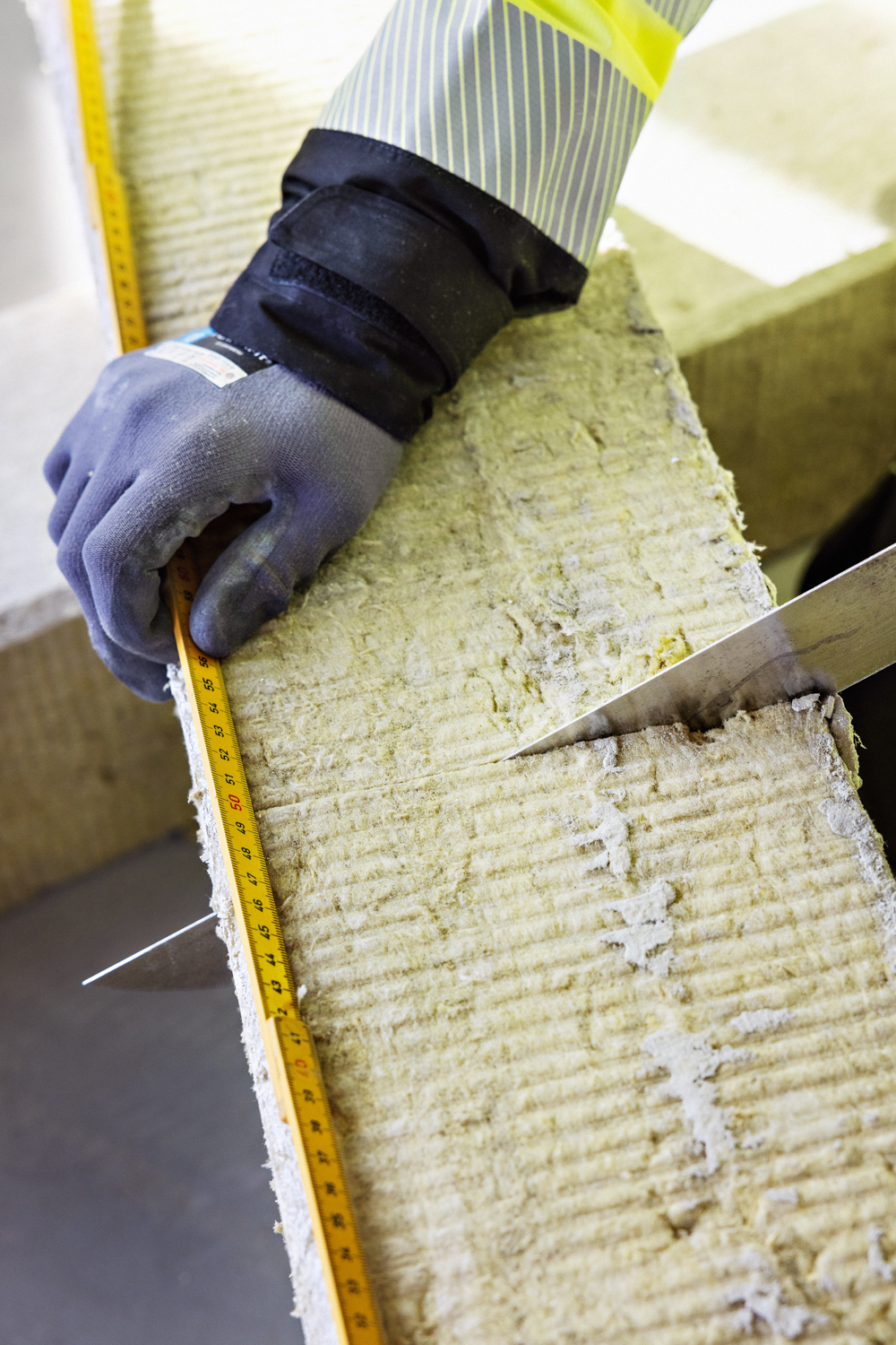 Nærbilde av isolasjon som blir skjært opp