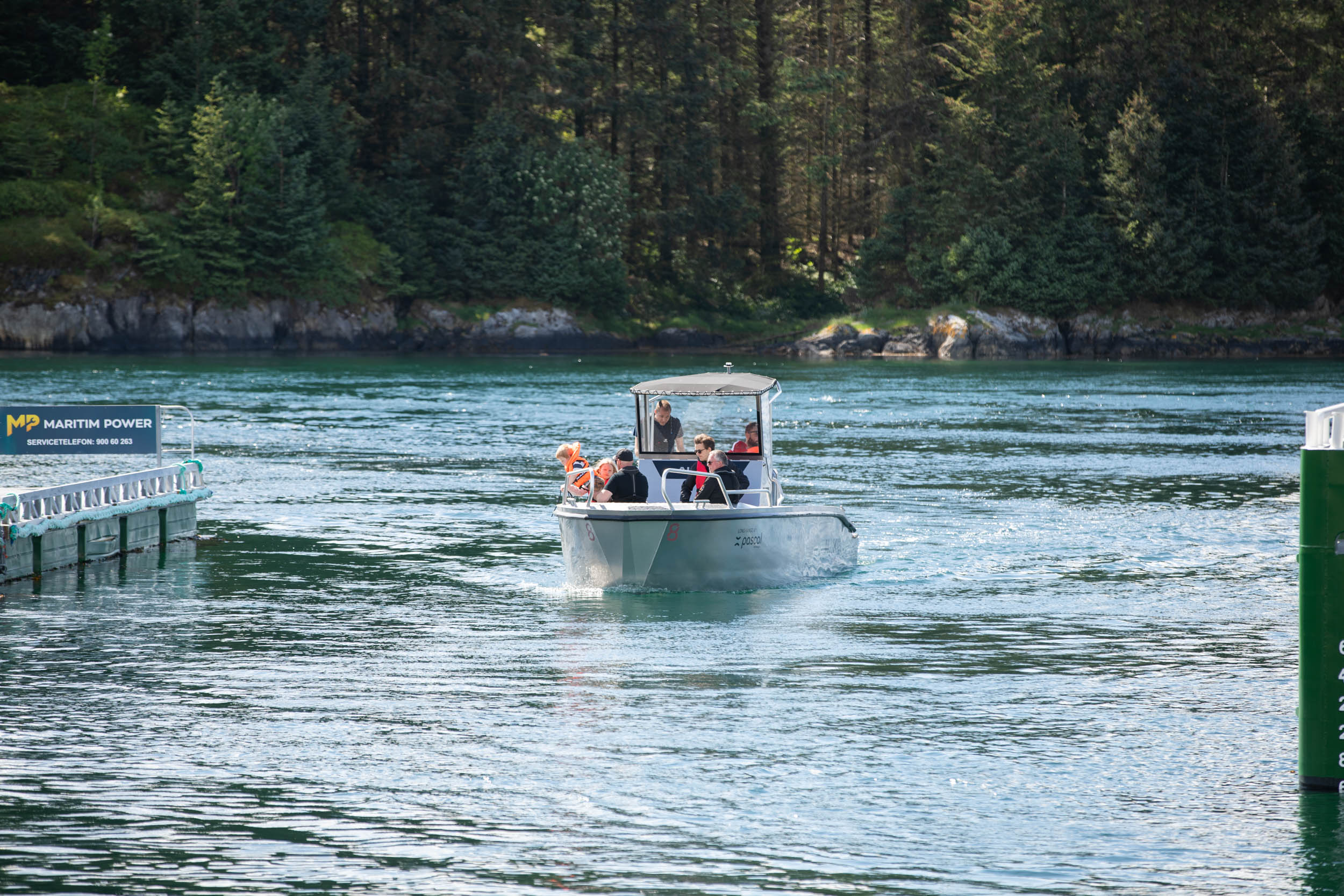 En liten båt kjører inn mot et havneområde