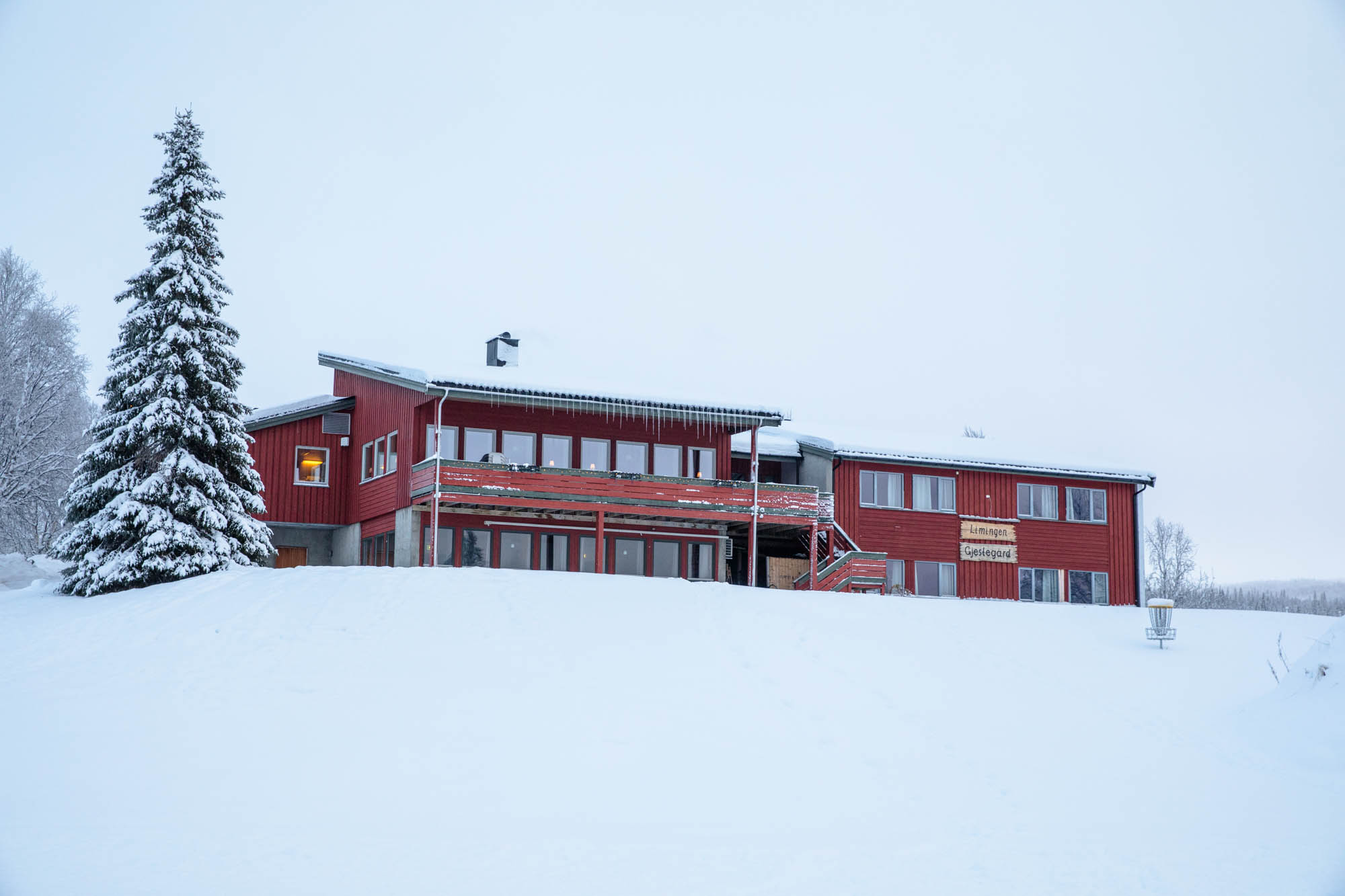 Fasadebilde av en gjestegård som ligger landlig til i et vinterlandskap