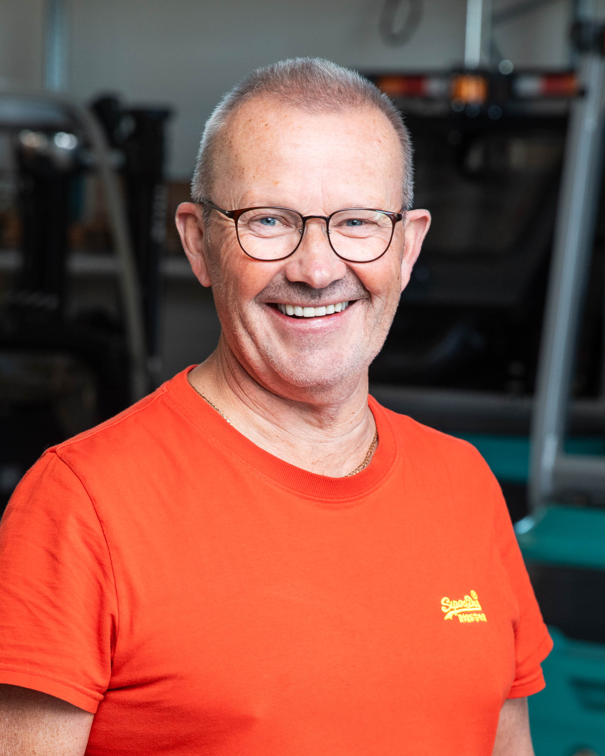 Ansattfoto av en mann som smiler mot kamera inne i et verksted