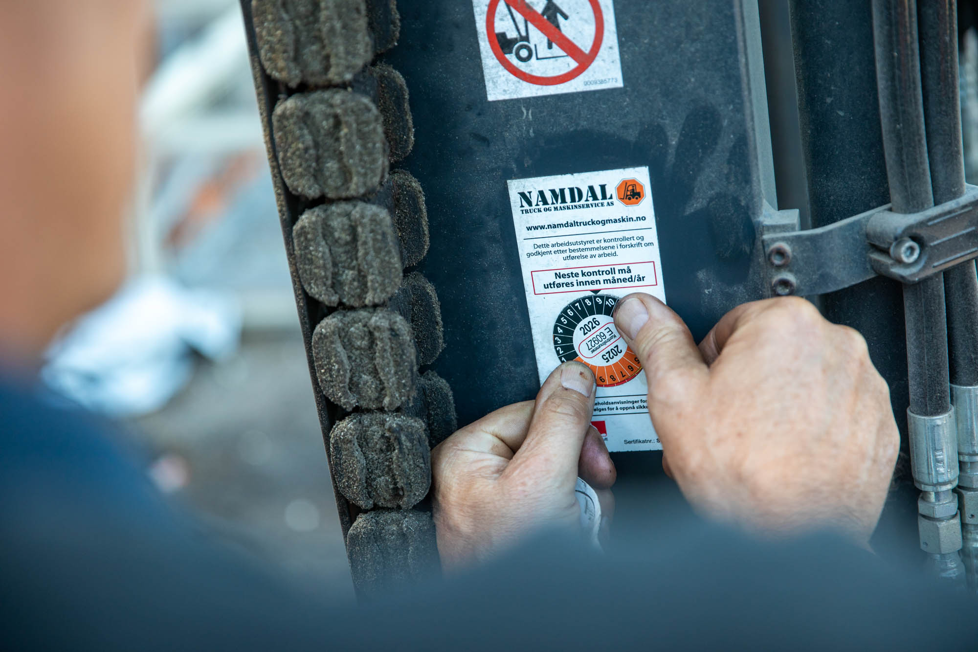 Nærbilde av to tomler som klistrer på et klistremerke