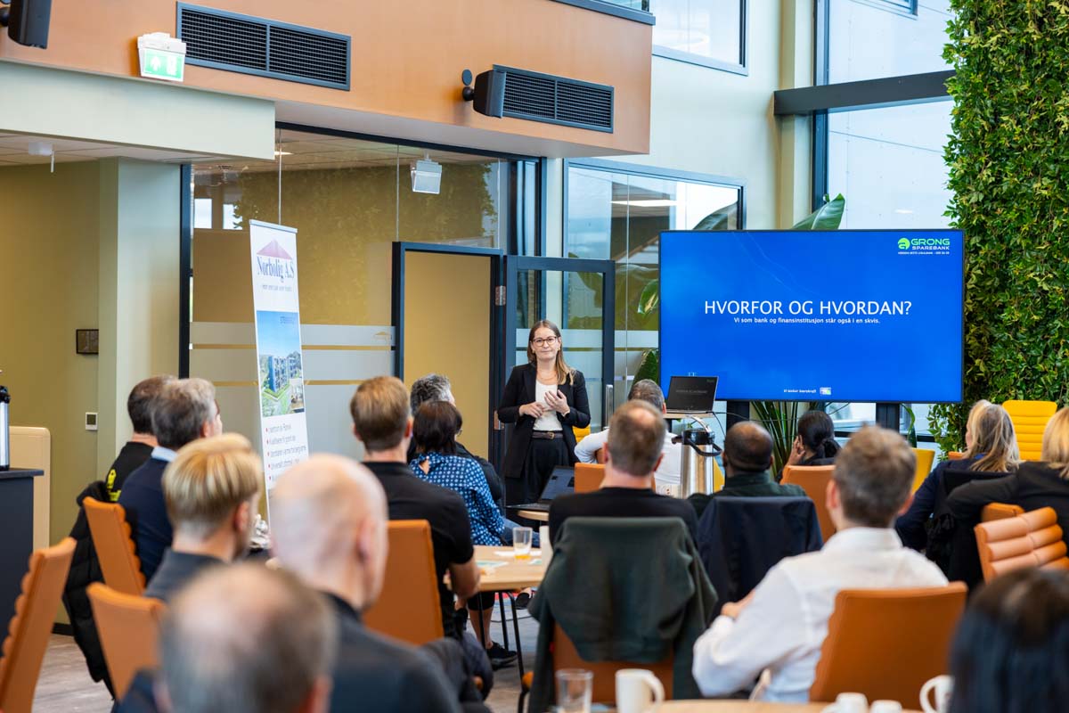 En kvinne presenterer på vegne av Grong Sparebank, i forgrunnen et tilskuere som hører på