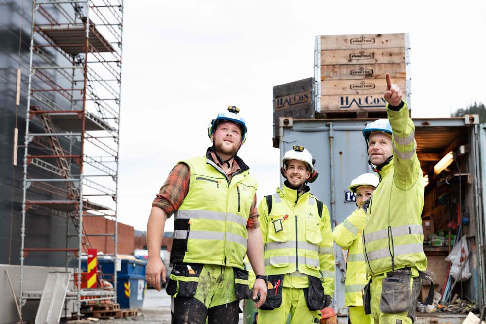 Fire personer på byggeplass i synlighetsklær