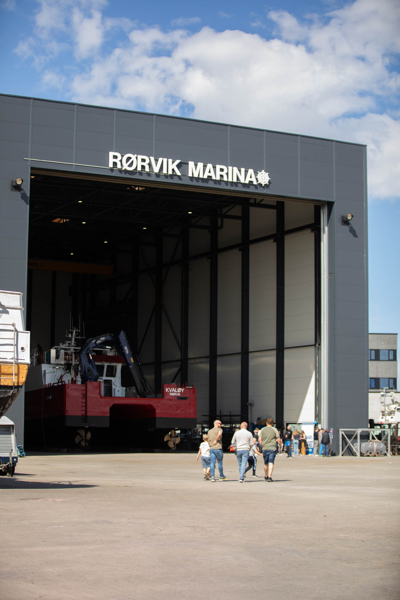 Fasaden til en stor båthall der porten er åpen