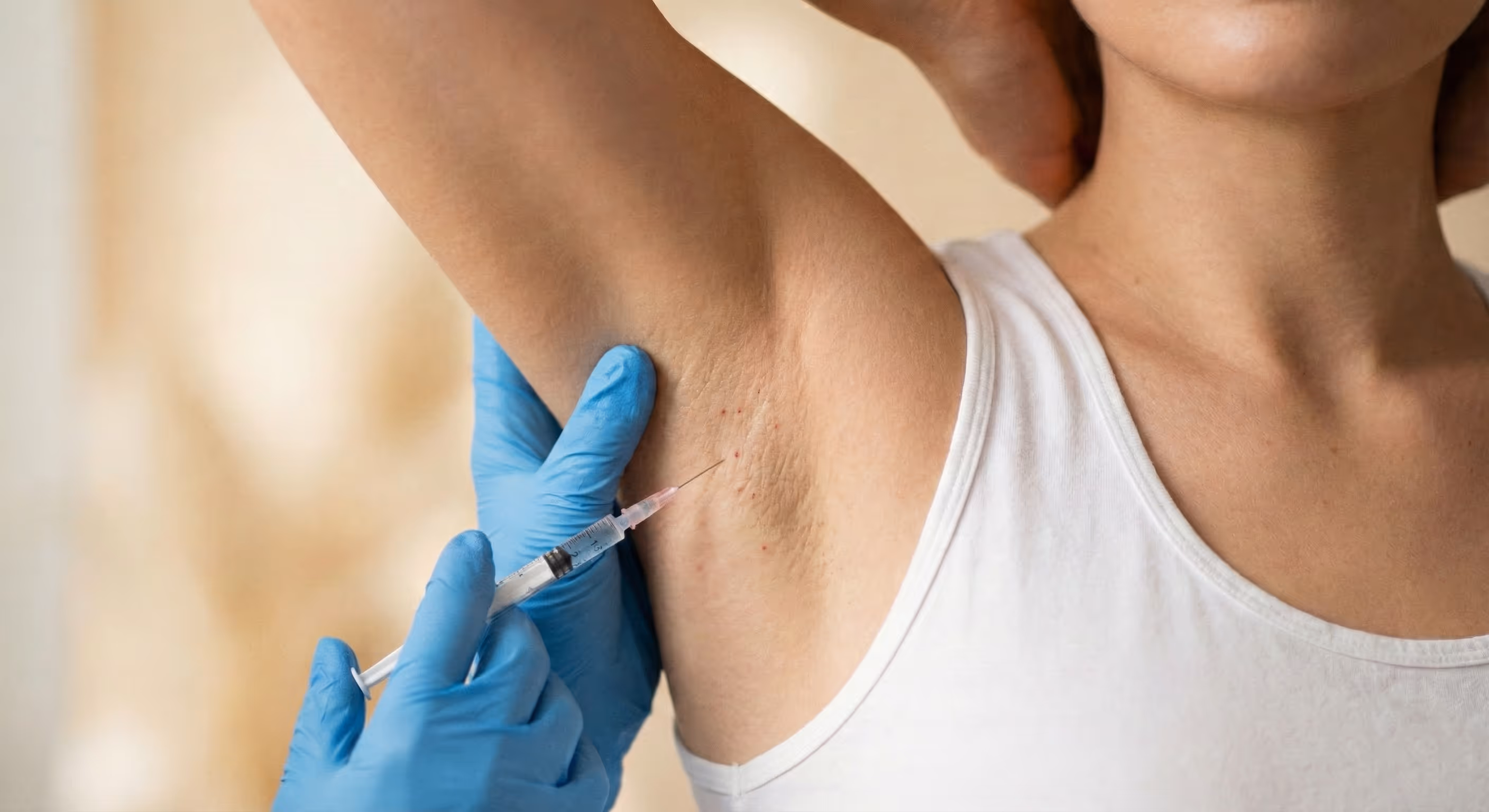 Nahaufnahme von glatter, gepflegter Achselhaut vor einem weichen, neutralen Hintergrund.