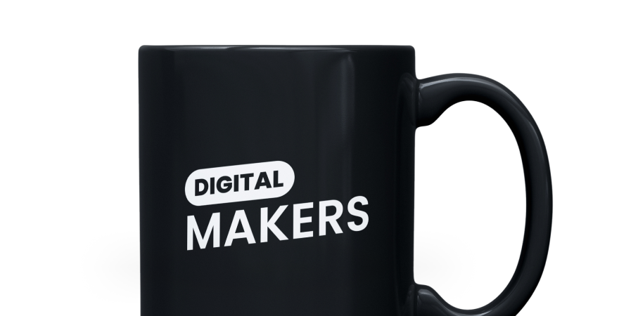 A black Digitalmakers mug with the logo, photographed against a dark background