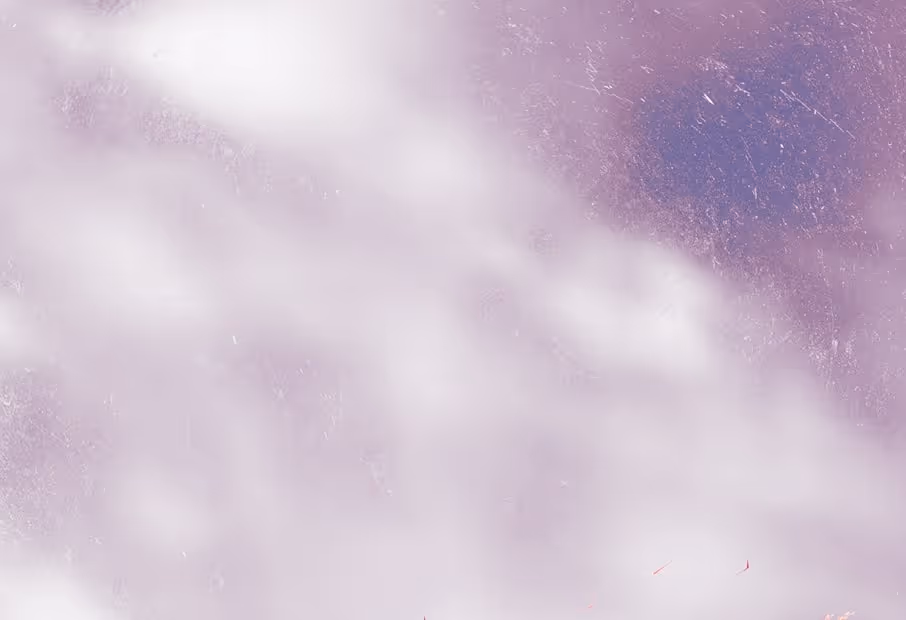 Cloudy sky with a large area of white clouds against a pinkish-purple background.