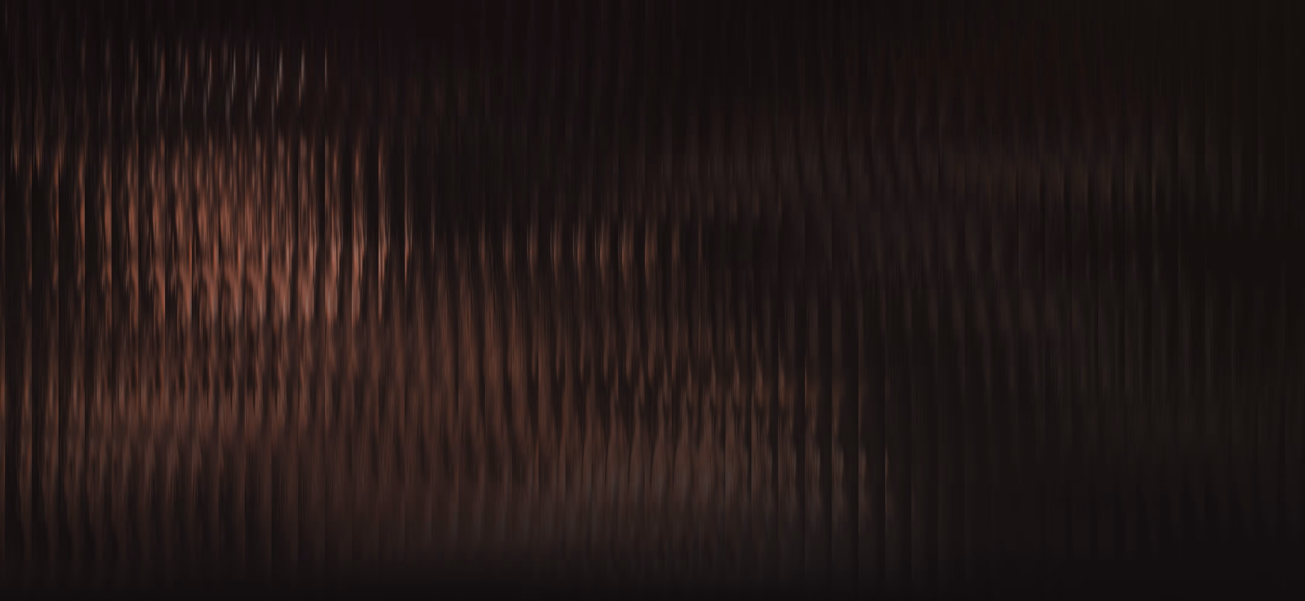 Abstract dark brown and black vertical ripple pattern resembling wood grain texture.