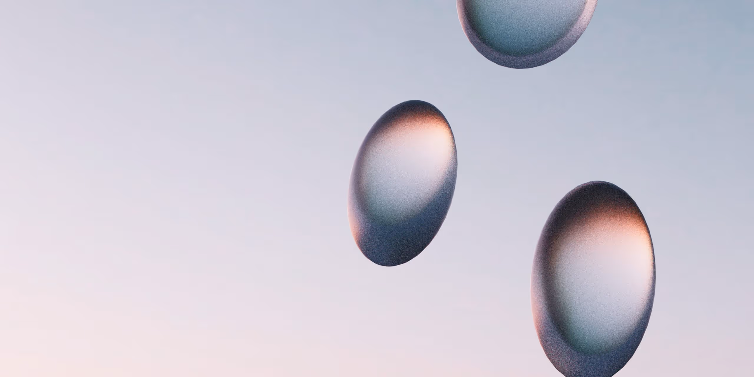 Three translucent oval shapes with gradient shading floating on a light blue and pink background.