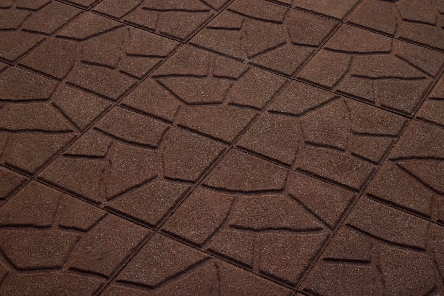 Crazy Pattern square concrete paving tiles in deep earthy brown with an irregular broken-stone design and a shot-blasted surface