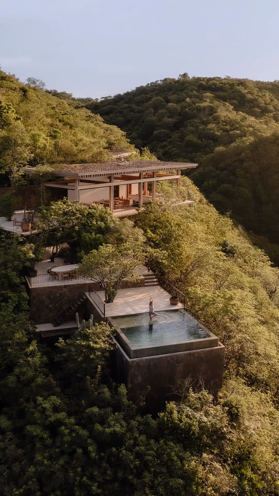 Vista aérea de la playa de arena blanca y la arquitectura tropical del hotel La Valise Los Cabos ubicado en la jungla.