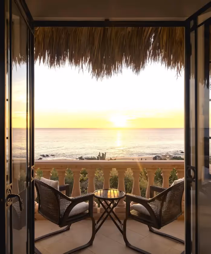 Mujer con un vestido de lino que atraviesa una puerta circular en el hotel La Valise Los Cabos, mostrando un diseño interior mexicano minimalista y orgánico.