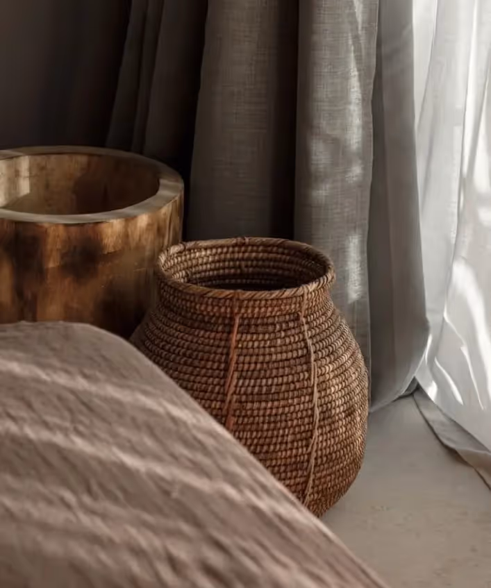 Un hombre que se zambulle en la piscina turquesa del hotel La Valise Los Cabos, que cuenta con lujosas tumbonas, sombrillas blancas y una exuberante vegetación tropical.