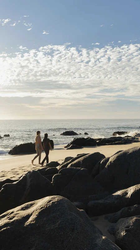 Silueta de una persona de pie en un acantilado rocoso con vista al paisaje desértico, hotel La Valise Los Cabos.