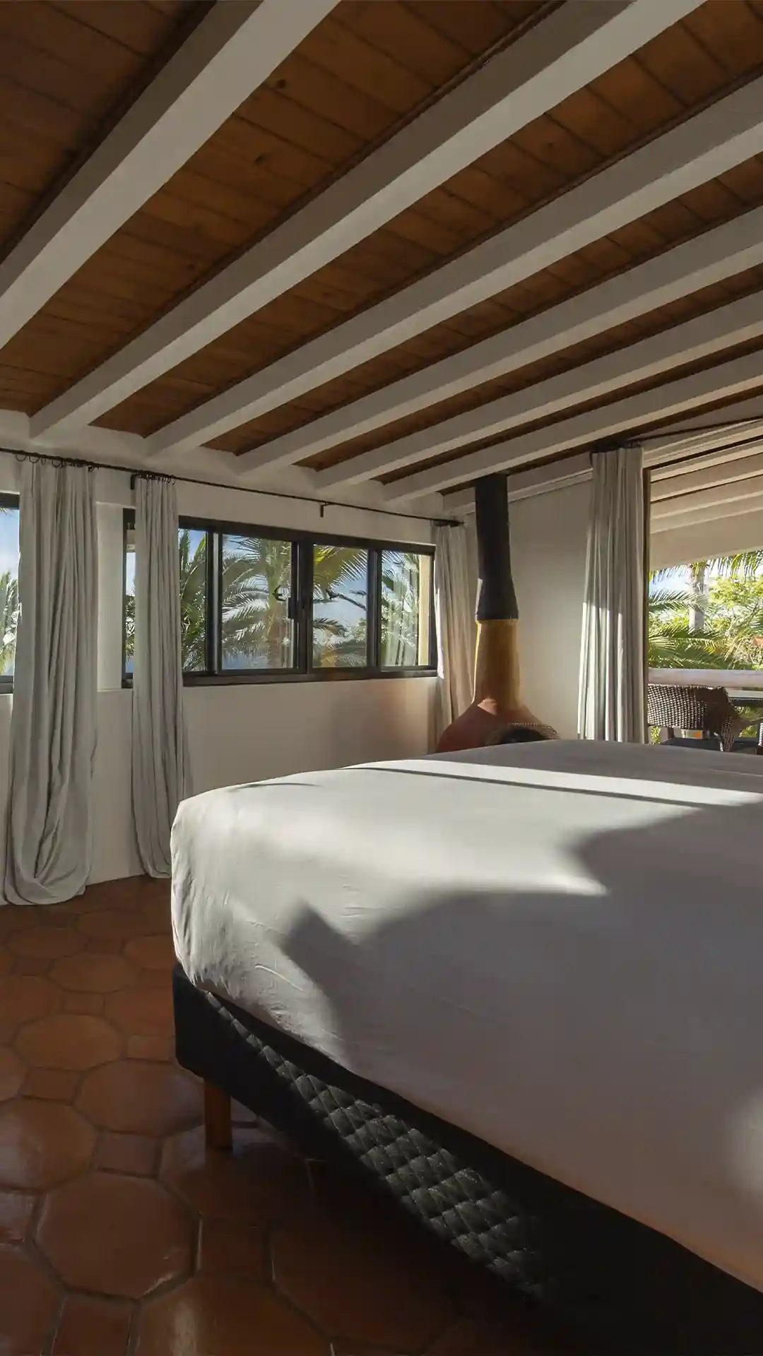 Lujosa suite con cama de dosel y suelos de terracota en el hotel La Valise Los Cabos.