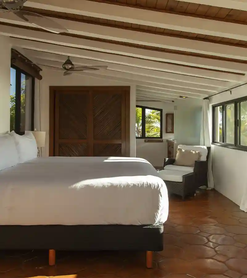 Lujosa suite con cama de dosel y suelos de terracota en el hotel La Valise Los Cabos.