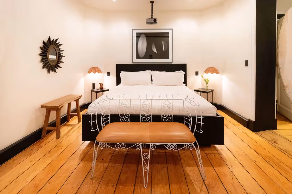 Luxury bedroom featuring wooden floors and a king-size bed at La valise Mexico city hotel.